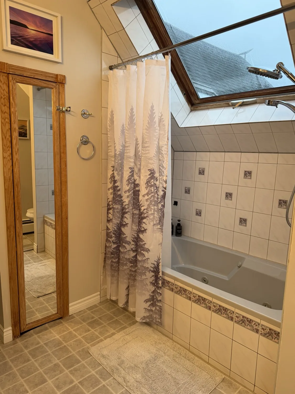 Bright bathroom with a skylit soaking tub and rain shower for the Orchard Room