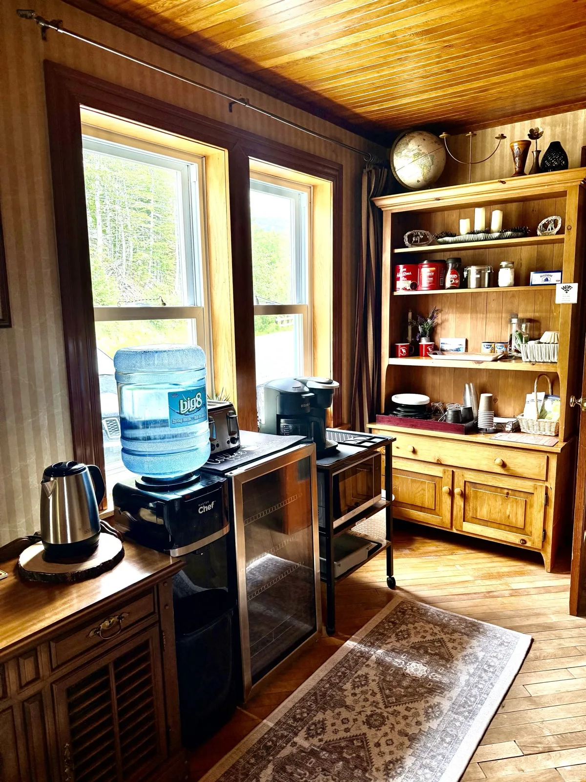 Common room amenities: coffee maker, kettle, water cooler, mini fridge and a wooden hutch of dishes