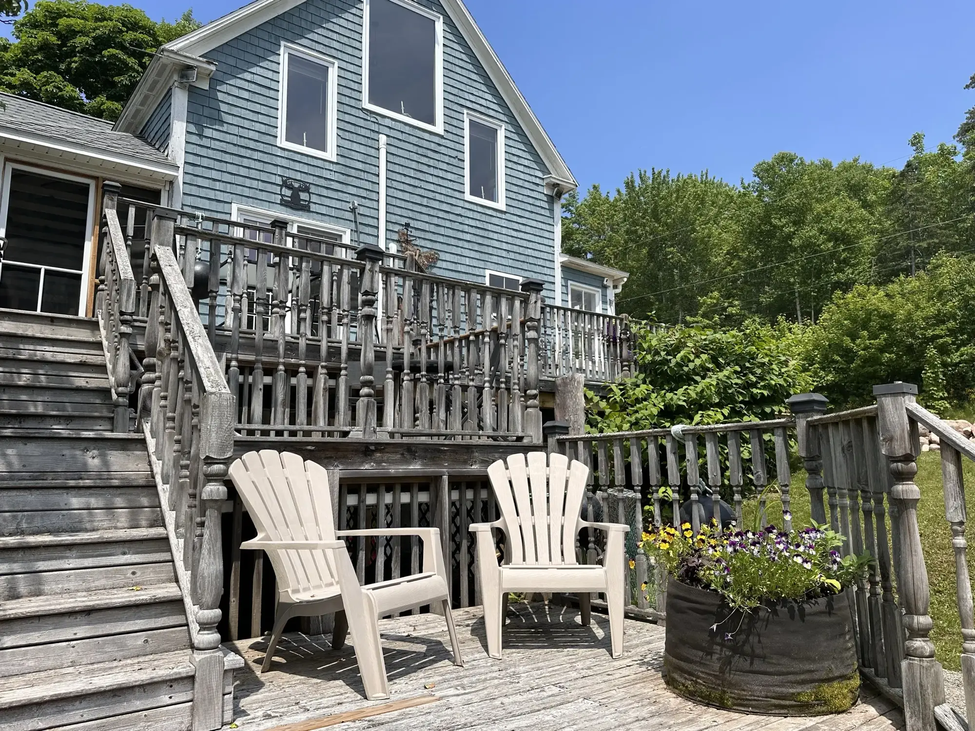 Adirondack chairs on the back deck below the blue century home