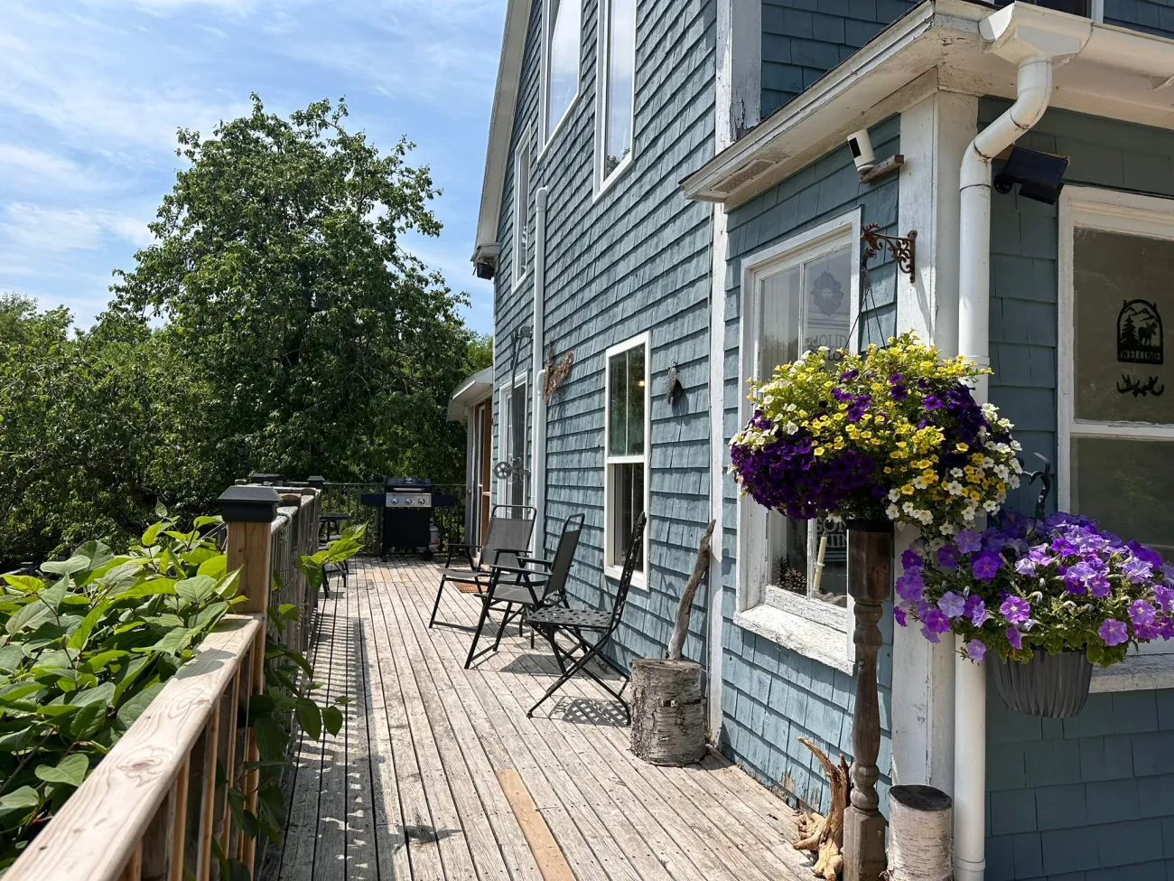 The lodge's blue cedar shingles, deck and summer flower baskets